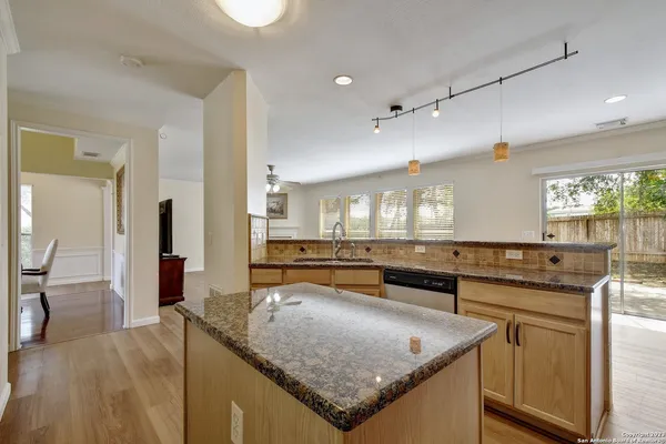 a kitchen with stainless steel appliances granite countertop a sink and a stove