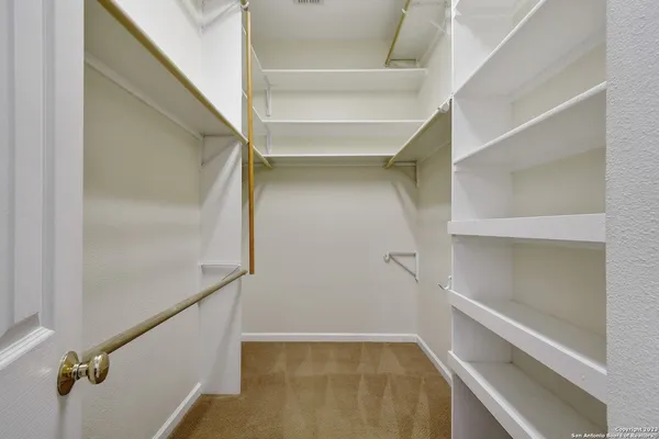 a view of walk in closet with empty racks