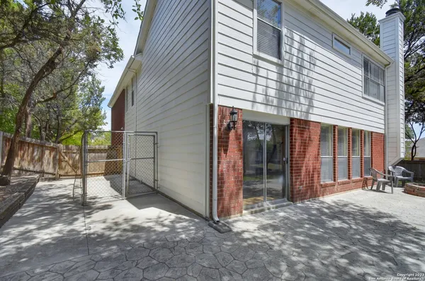 a view of backyard with wheel chair and wooden fence