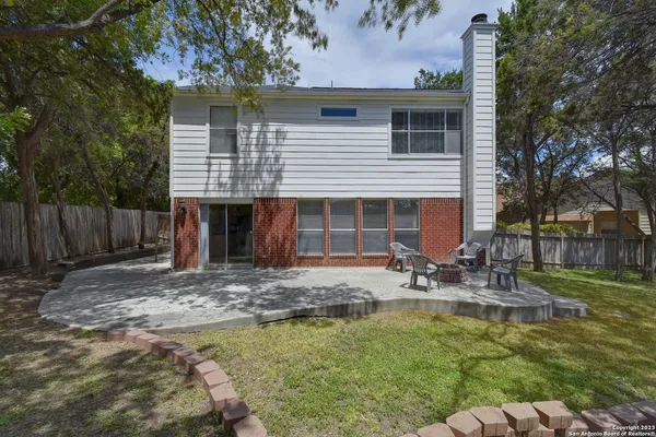 a front view of a house with swimming pool and chairs