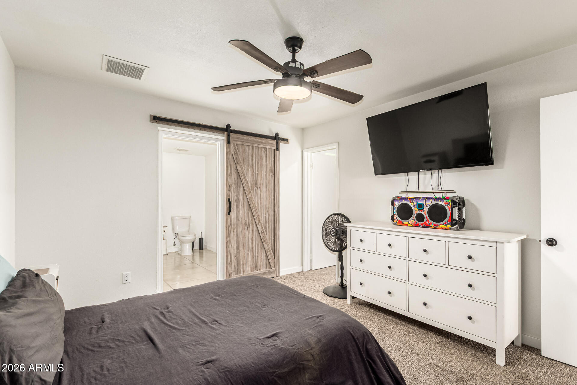 1609 West Mission Lane Phoenix, AZ 85021 - Photo 5 of 36 a bedroom with a bed a flat screen tv and a chandelier