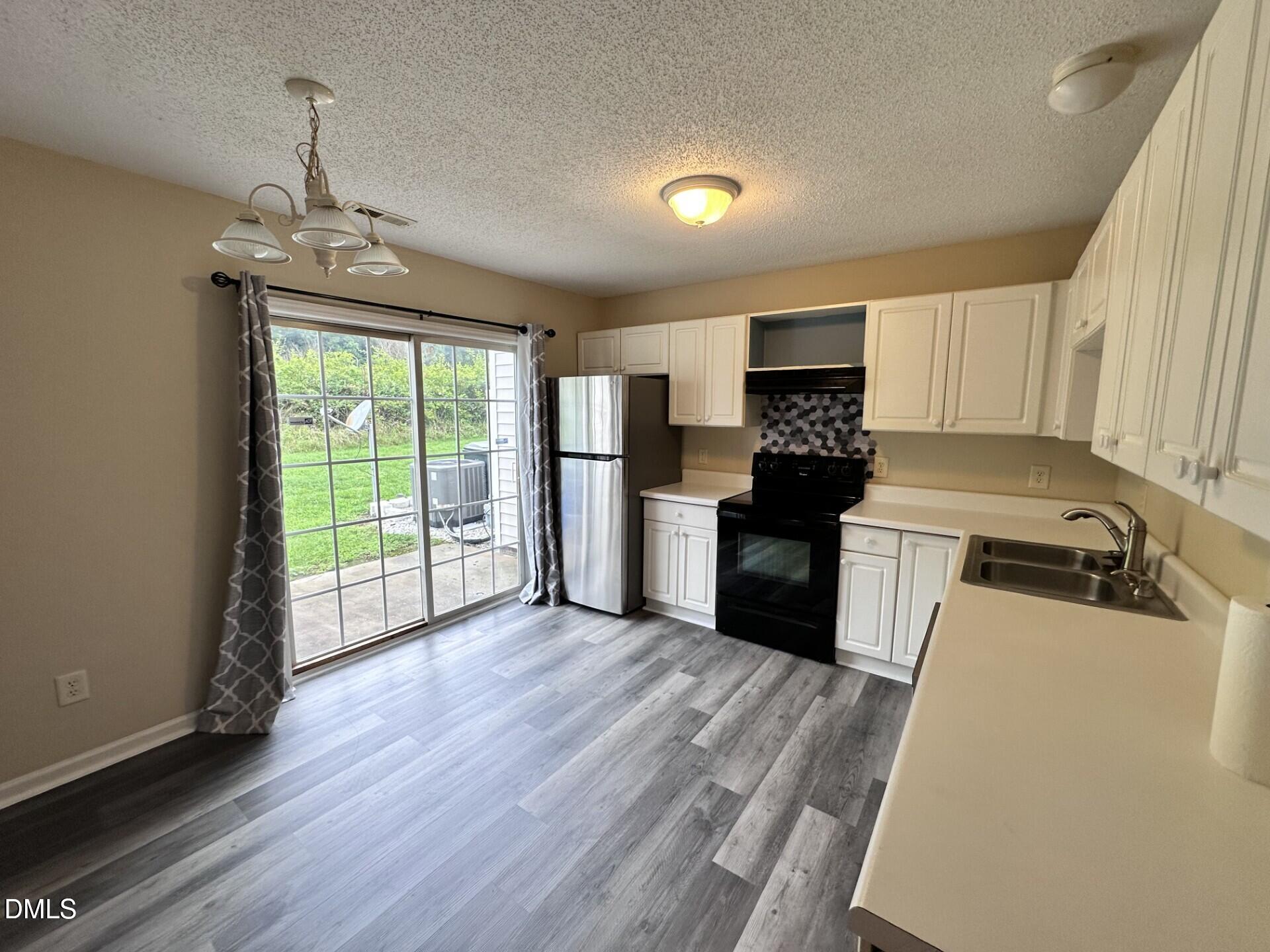 2112 Walnut Bluffs Lane Raleigh, NC 27610 - Photo 7 of 17 a kitchen with granite countertop a stove top oven a sink and cabinets