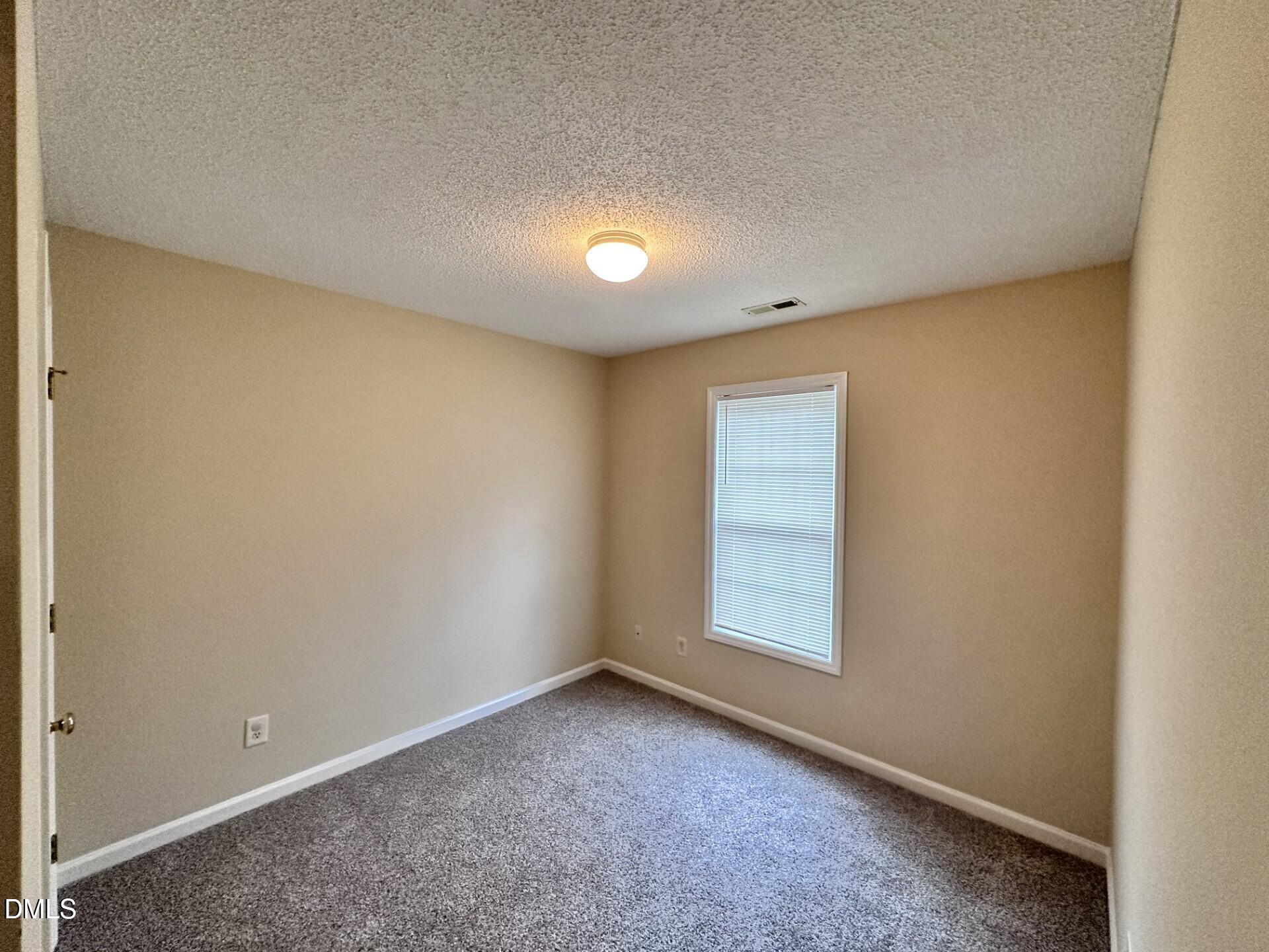 2112 Walnut Bluffs Lane Raleigh, NC 27610 - Photo 10 of 17 an empty room with a empty space and windows