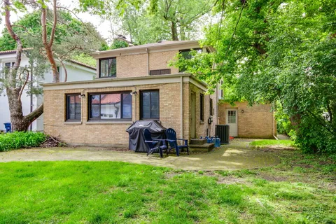 a view of a house with backyard and sitting area