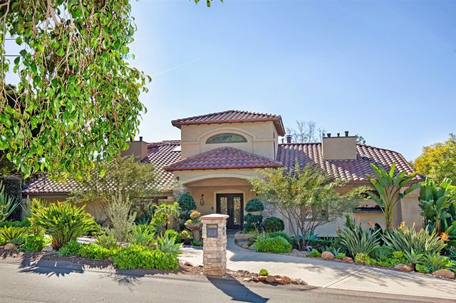 a front view of multi story residential apartment building with yard and retail shops