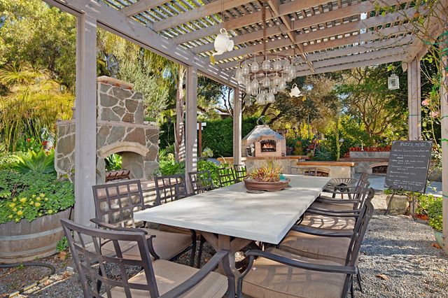 a view of a patio with table and chairs potted plants with floor to ceiling window plants and outdoor seating