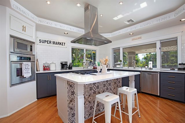 a kitchen with stainless steel appliances granite countertop a sink and a stove