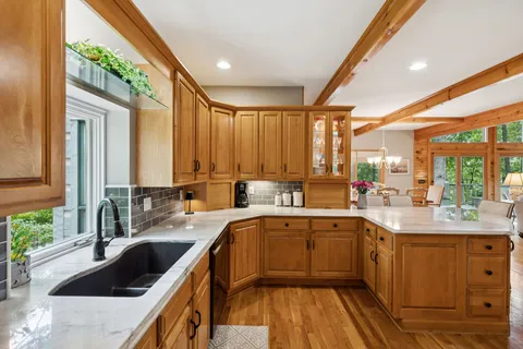 a spacious bedroom with a bed painting on wall and a large window
