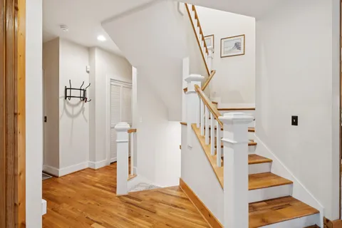 a bedroom with a bed a desk and chair with windows