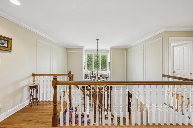 a view of a hallway with wooden floor and staircase
