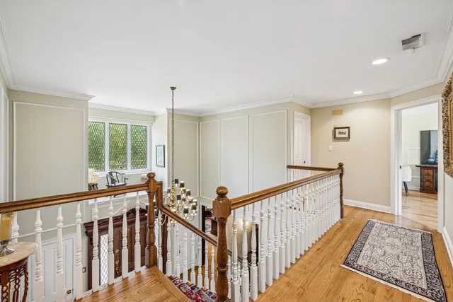 a view of a hallway with wooden floor and windows