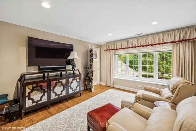 a living room with furniture a flat screen tv and a window