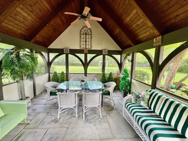 a roof deck with table and chairs under an umbrella with a barbeque