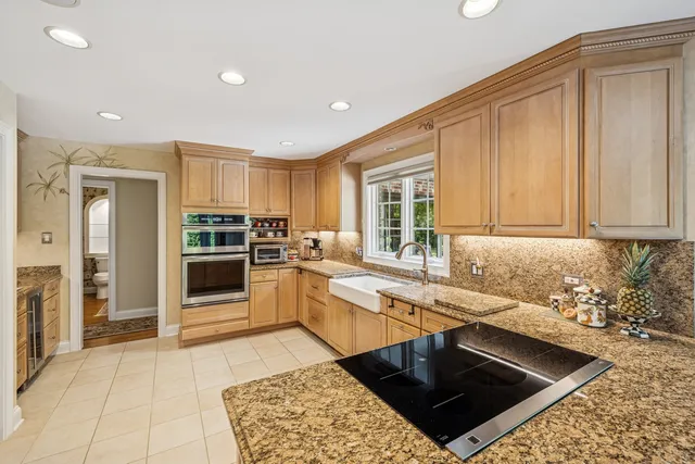 a kitchen with stainless steel appliances granite countertop a stove a sink and a refrigerator