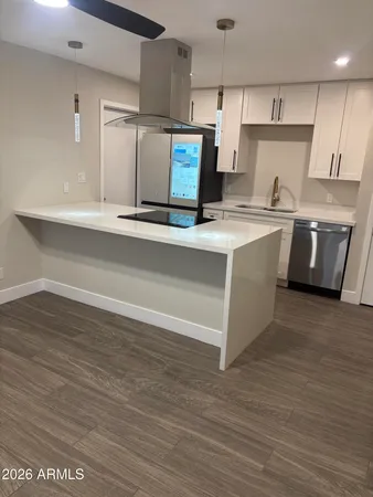 a kitchen with stainless steel appliances granite countertop a sink a stove and a refrigerator