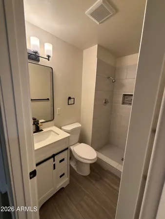 a bathroom with a granite countertop sink toilet and shower
