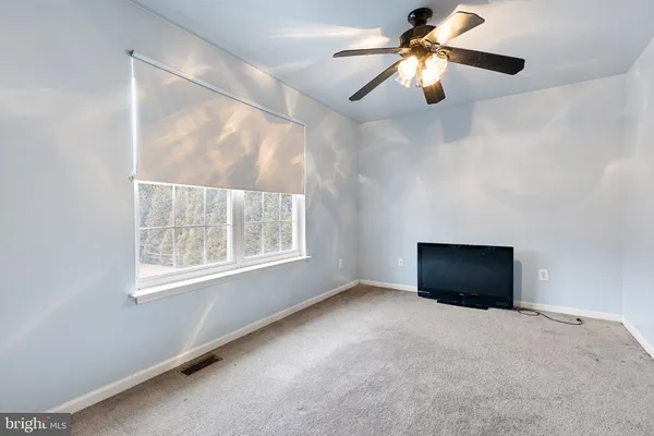a view of room with window and a ceiling fan