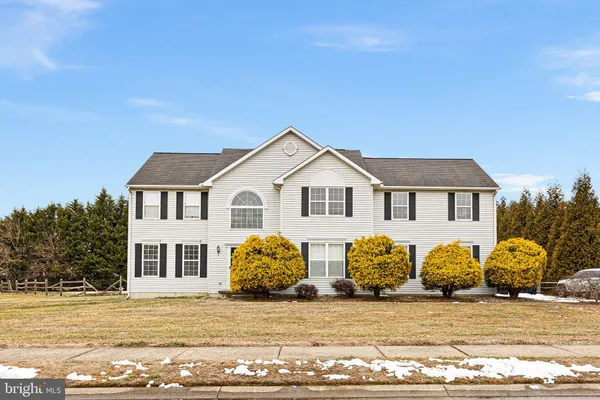 a view of a white house with a yard in front of it