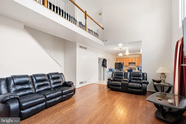 a living room with furniture ceiling fan and wooden floor
