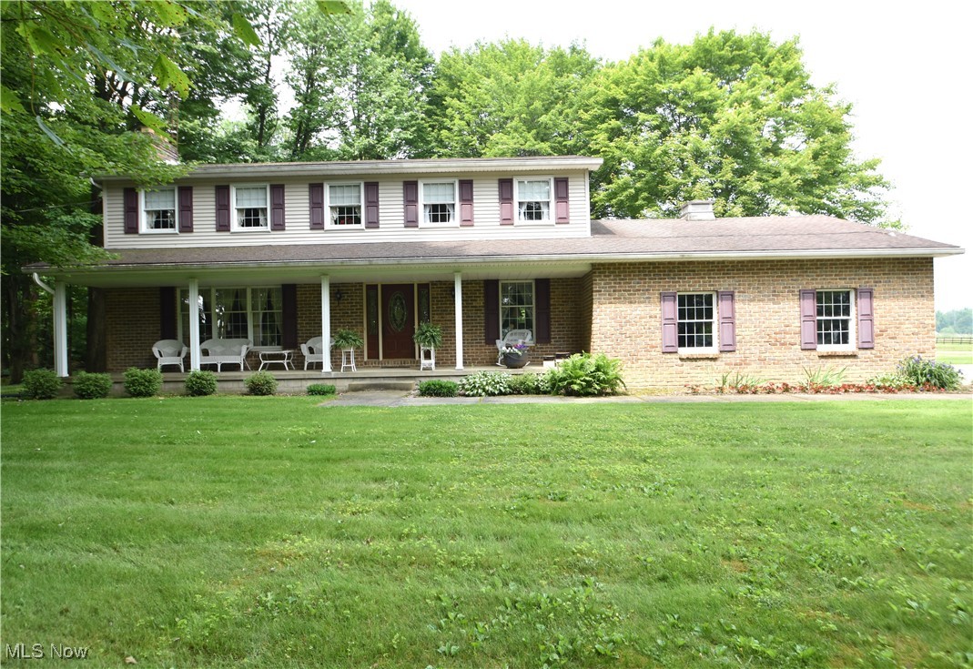 11676 Lisbon Road Salem, OH 44460 - Photo 1 of 38 Colonial home featuring a chimney, a porch, brick siding, and a front yard