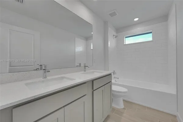 a bathroom with a granite countertop sink a toilet and a bathtub