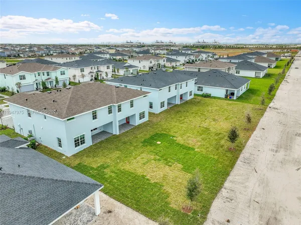 an aerial view of residential houses with outdoor space and ocean view