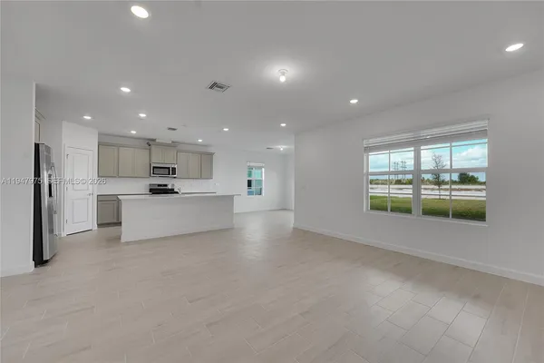 a view of kitchen with refrigerator and window