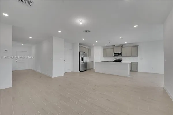 a view of kitchen with kitchen island a stove and a refrigerator