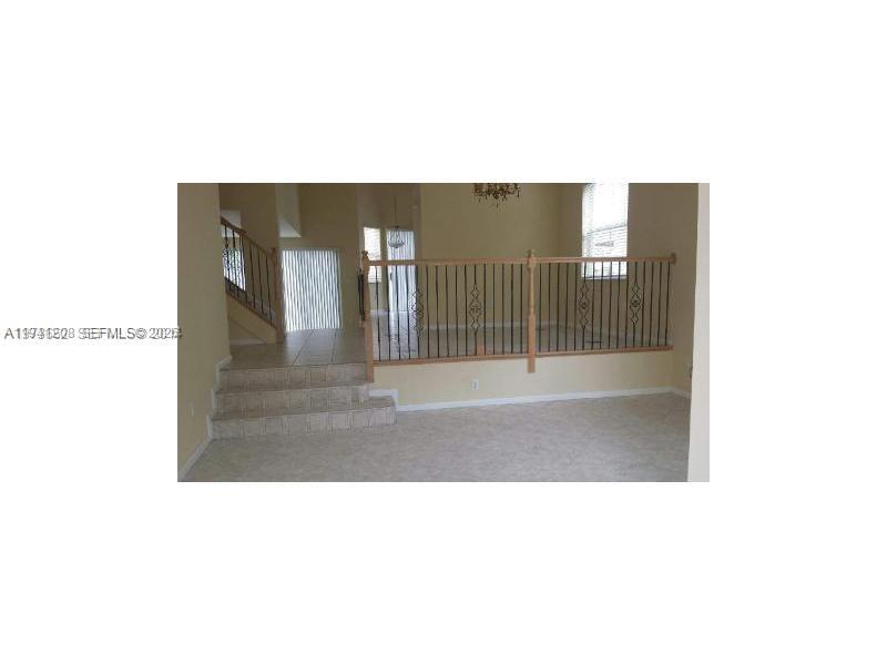 15880 Southwest 50th Street Miramar, FL 33027 - Photo 7 of 8 a open living room with a wooden floor