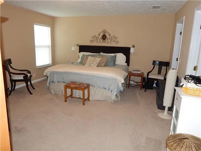 a bedroom with a bed and a chair