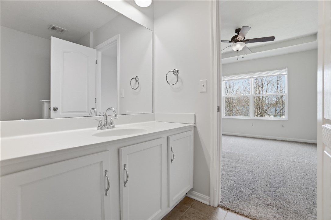4294 Straight Arrow Road Dayton, OH 45430 - Photo 27 of 41 This primary bathroom offers a modern vanity, a large mirror, and access to a carpeted bedroom.