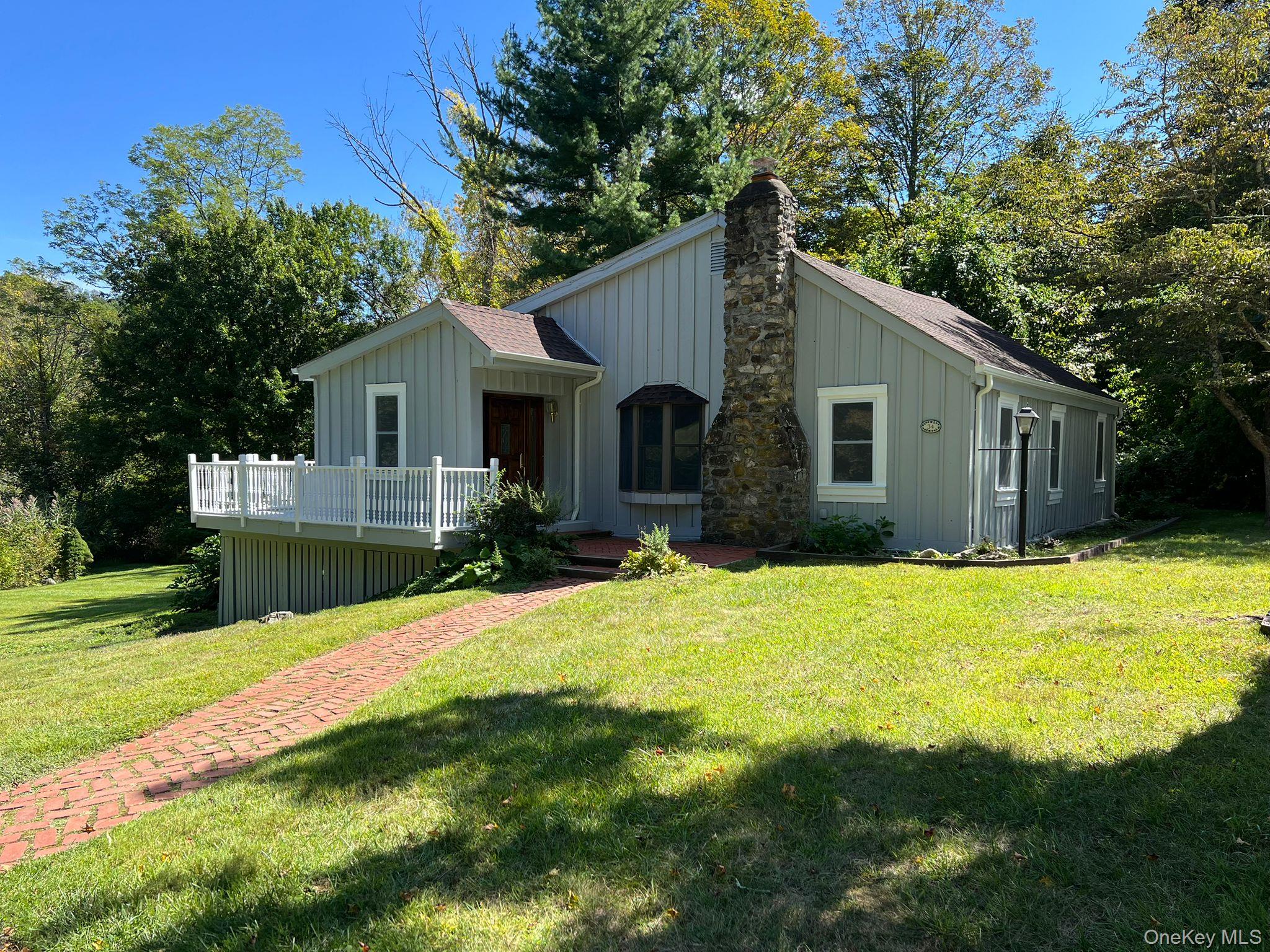 34 Glenacom Road Mahopac, NY 10541 - Photo 1 of 1 View of front of property featuring board and batten siding, a front lawn, a shingled roof, a chimney, and a deck
