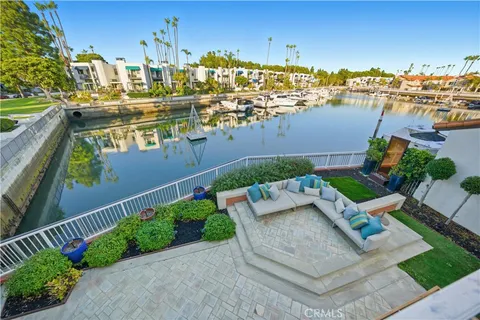 a view of a patio with couches table and chairs with wooden floor and fence