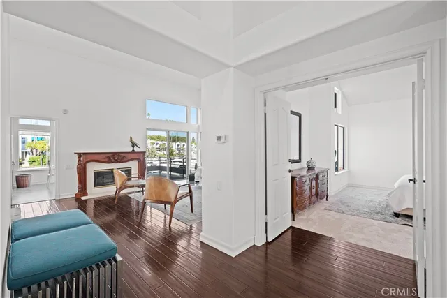 a living room with furniture and a large mirror next to a window