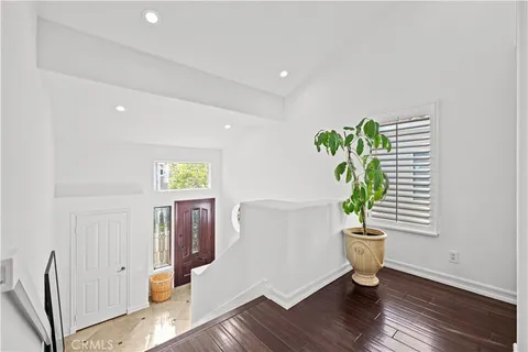 a living room with furniture and a large mirror next to a window