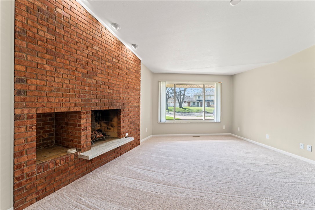 2247 East Whipp Road Dayton, OH 45440 - Photo 13 of 52 This inviting living area features a warm fireplace and expansive window, perfect for relaxation.