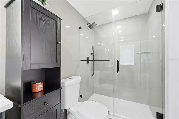 a bathroom with a toilet a sink and shower