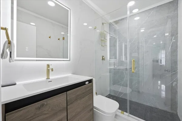 a bathroom with a sink a toilet and shower