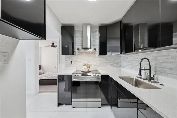 a kitchen with stainless steel appliances a sink stove and refrigerator