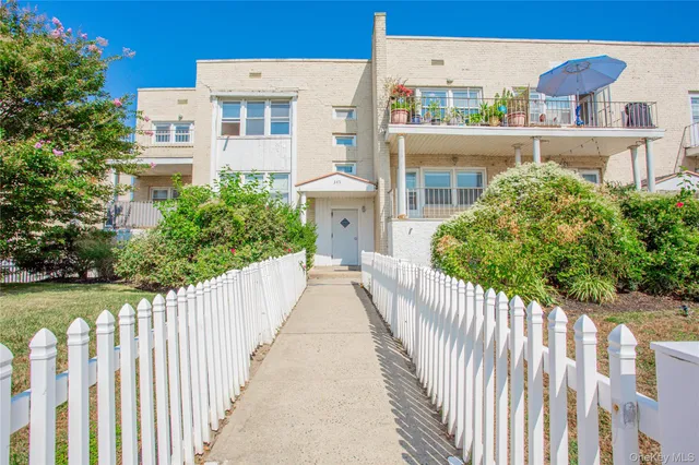 a view of a brick house with wooden fence