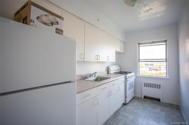 a kitchen with a sink cabinets and a window