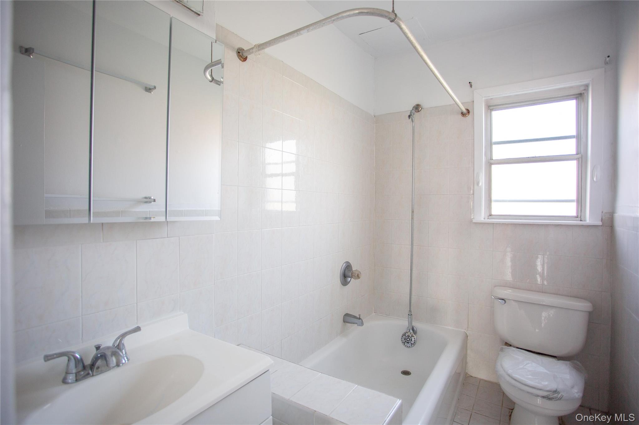 345 Shore Road, Unit 1E Long Beach, NY 11561 - Photo 8 of 13 a bathroom with a sink toilet and shower