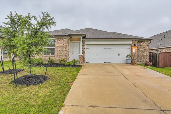 a front view of a house with a yard and a garage
