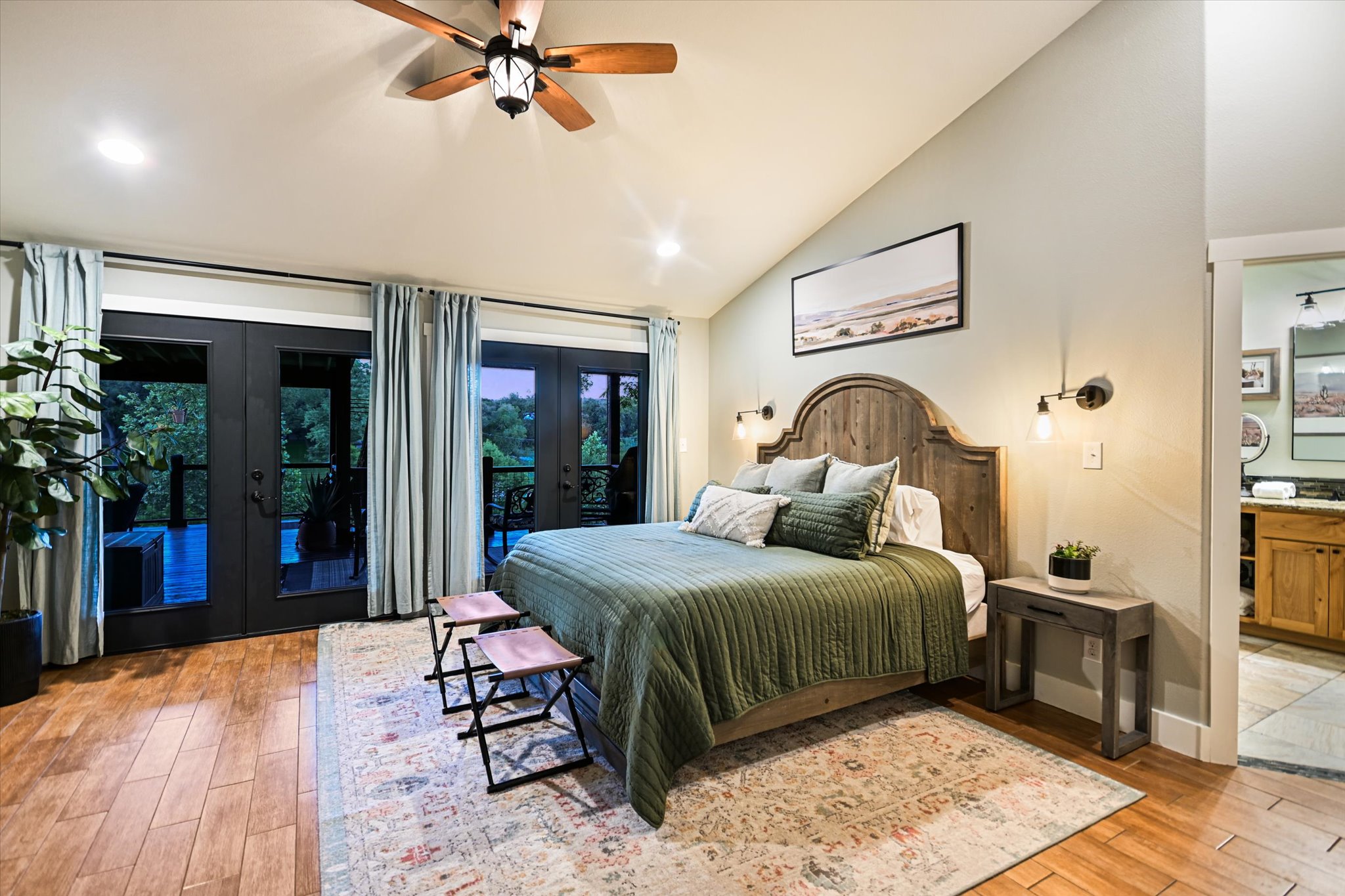 2411 Spoke Hollow Road Wimberley, TX 78676 - Photo 13 of 37 Elegant primary bedroom offers French doors leading to a private outdoor space, creating a serene retreat.