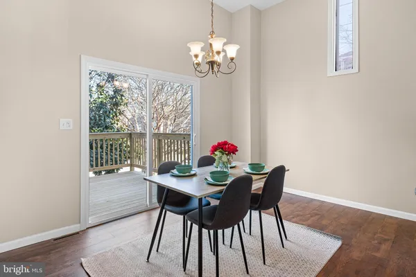 a view of a dining room with furniture a chandelier and wooden floor