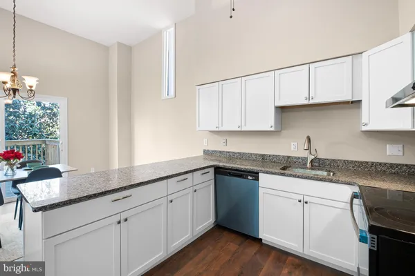a kitchen with granite countertop white cabinets white appliances and sink