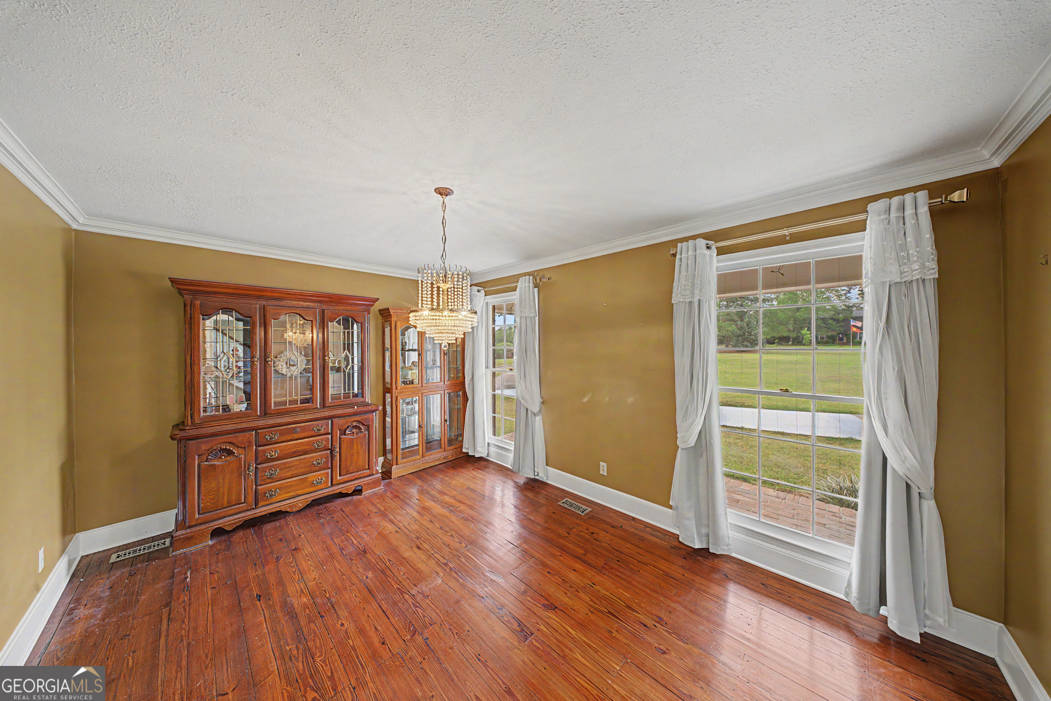 306 Holly Trail Moultrie, GA 31768 - Photo 3 of 40 a view of an empty room with a window and wooden floor