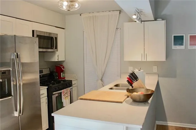 a kitchen with stainless steel appliances a refrigerator and a sink