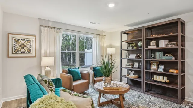 a living room with furniture and a book shelf