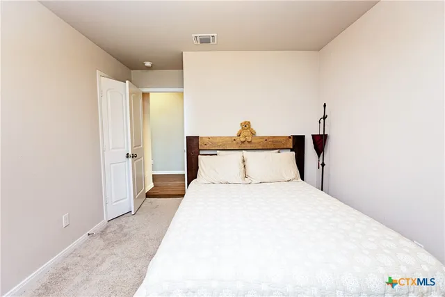 a bedroom with a bed and a potted plant